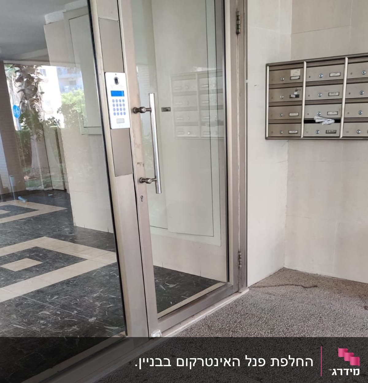 אינטרקום עם לוח מקשים ליד דלת זכוכית